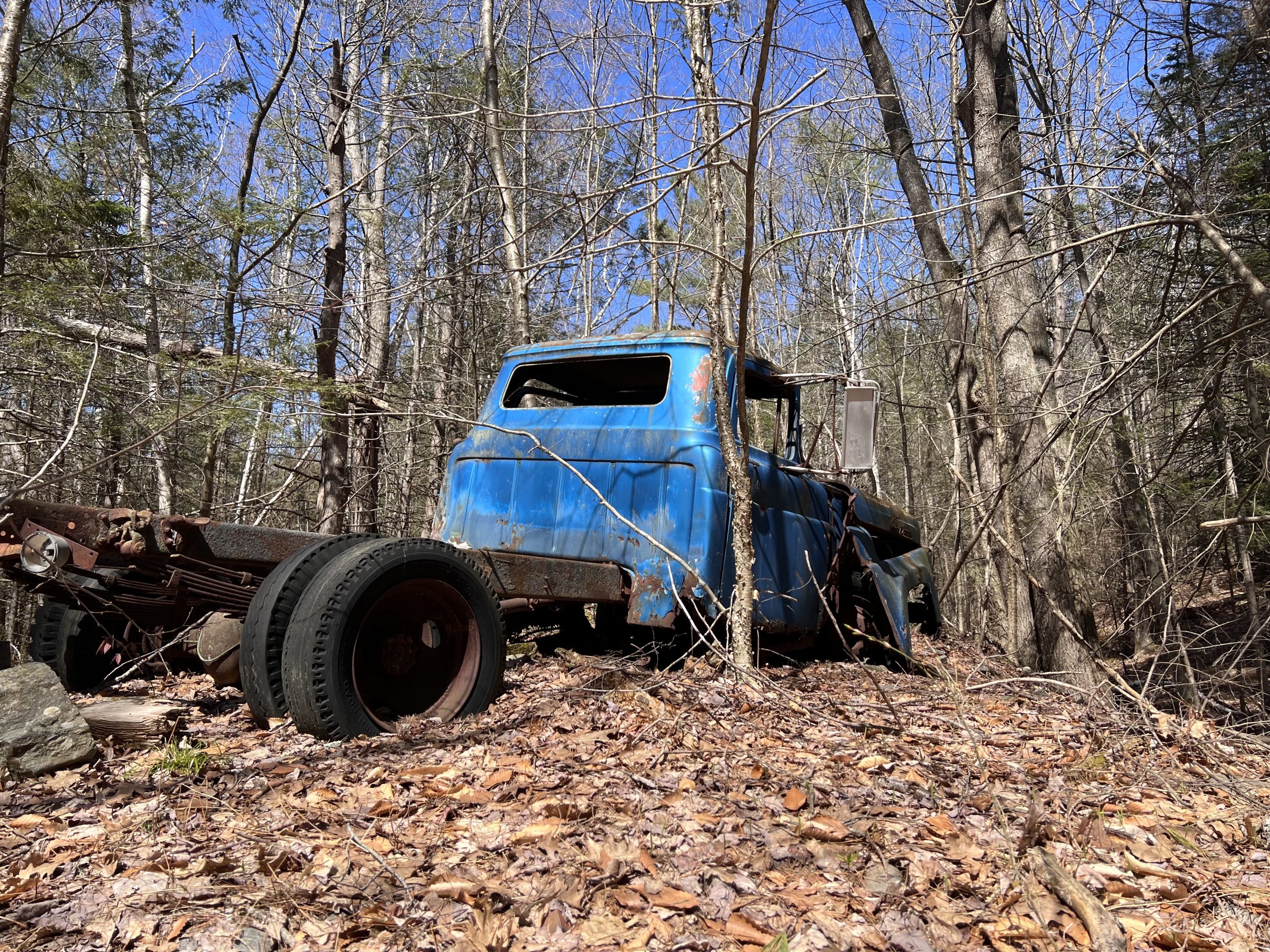 a photo of an abandoned blue pick-up truck in the Maine woods