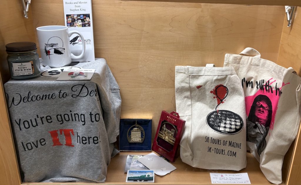 a selection of clothing, tote bags books and papers related to research for the book Stephen King's Maine by Sharon Kitchens