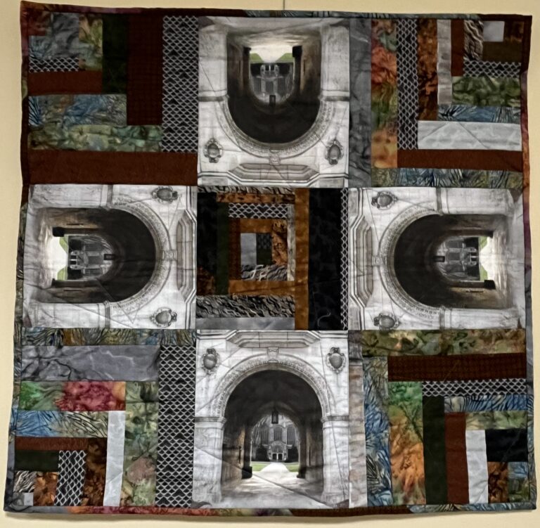 a quilt featuring four images of an arched stone doorway, arranged so that they form a cross in the center of the square quilt