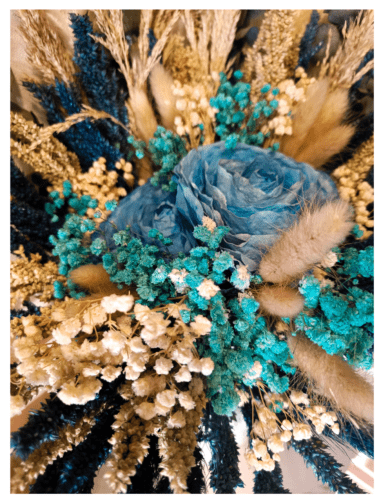 a bouquet of dried blue and beige flowers and leaves